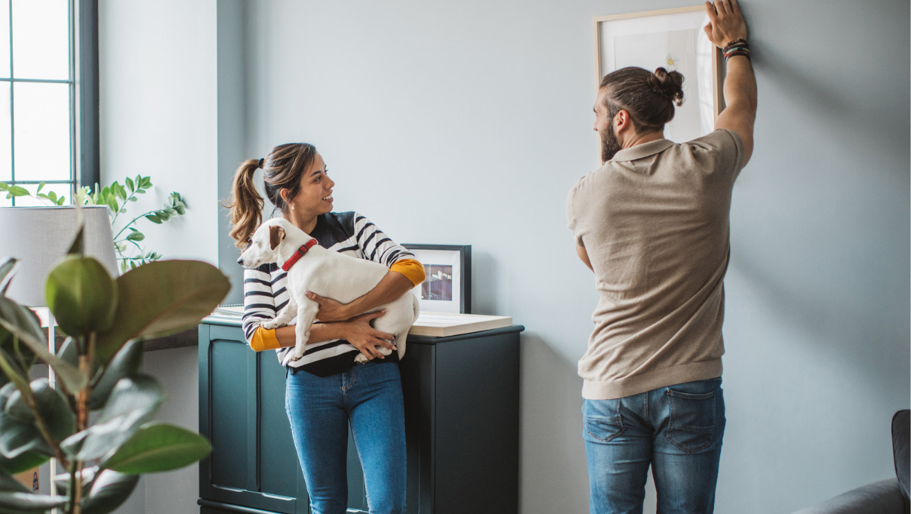 Couple hanging picture in new home