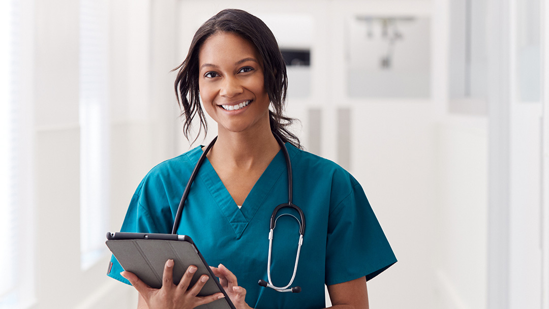Doctor in hospital corridor using iPad